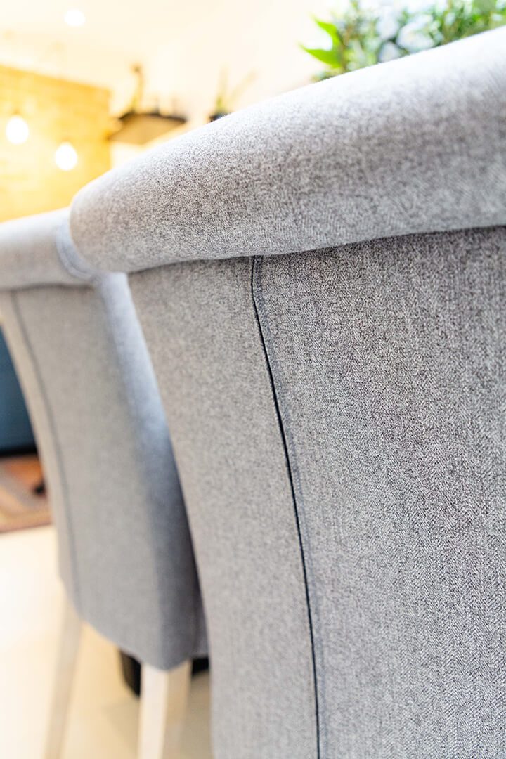 A close up of the back of a set of grey designer chairs.