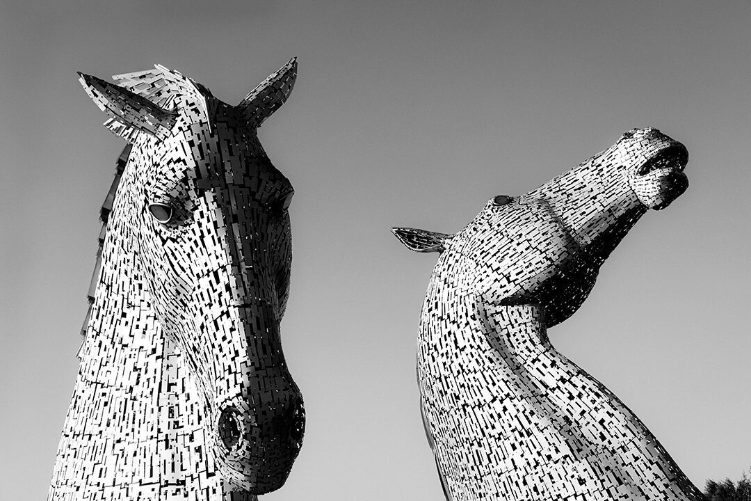 A black and white image of the Kelpies at Falkirk, Scotland showing just the horses heads against the sky