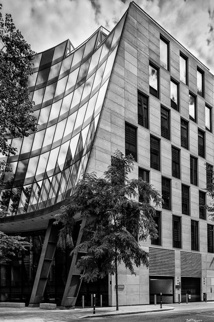 A black and white architectural photography of a building with curved glass in London