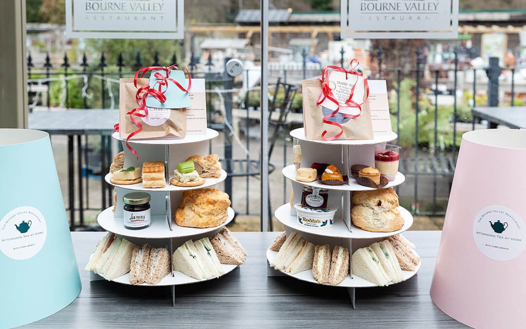 A set of cardboard display stands showing some take away afternoon teas in a garden centre.