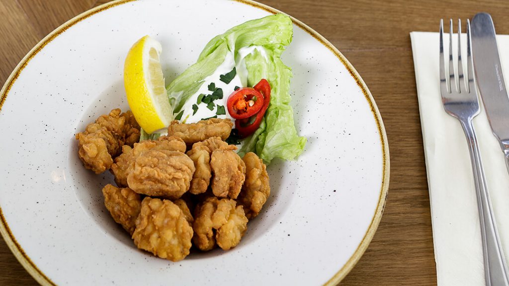 A tasty looking plate of calamari with side salad and sweet chilli as served in a pub.