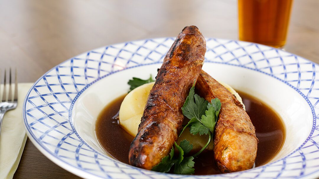 An appetising plate of sausage and mash with onion gravy. Image part of a marketing food shoot.