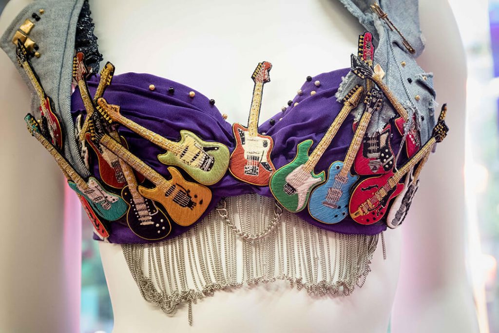 A detailed image of the Eric Clapton themed bra for the Walk the Walk charity launch event featured embroidered guitars.
