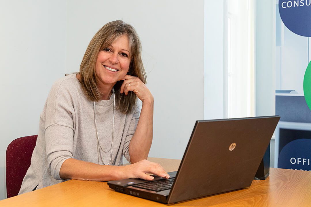A business owner posing at their desk for a corporate photoshoot