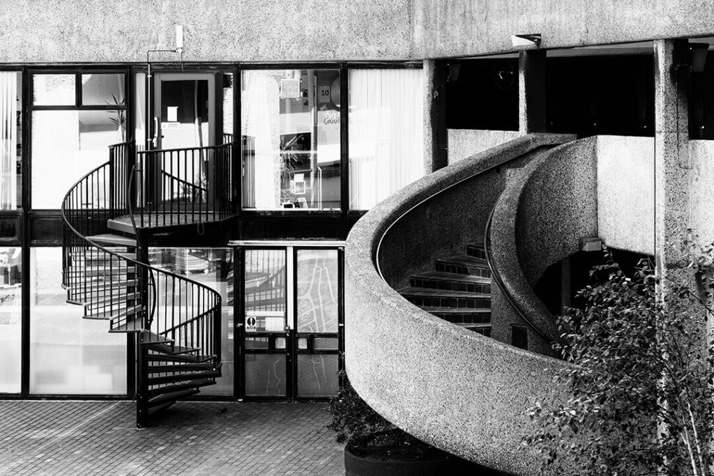 A black and white image of two contrasting spiral staircases.