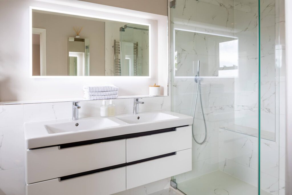 An image across a modern bathroom with built in cabinets.
